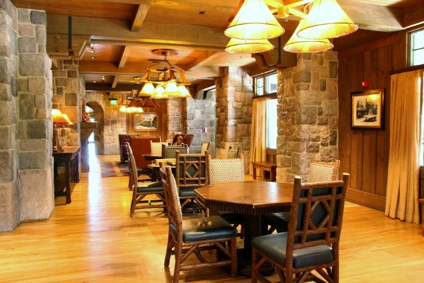 a wide view of a room with stone walls, tables and chairs