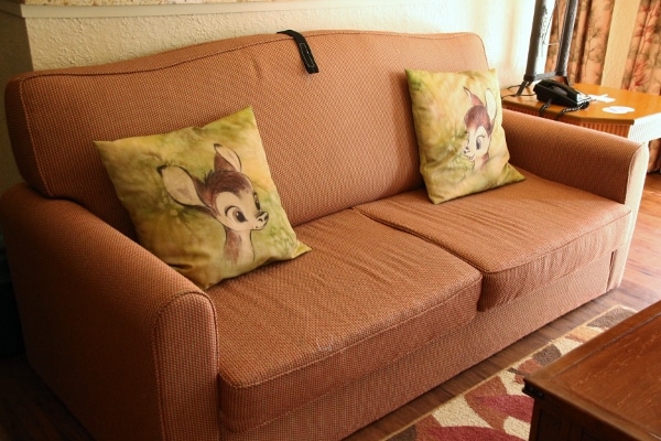 a sofa with pillows with Bambi pictured on them