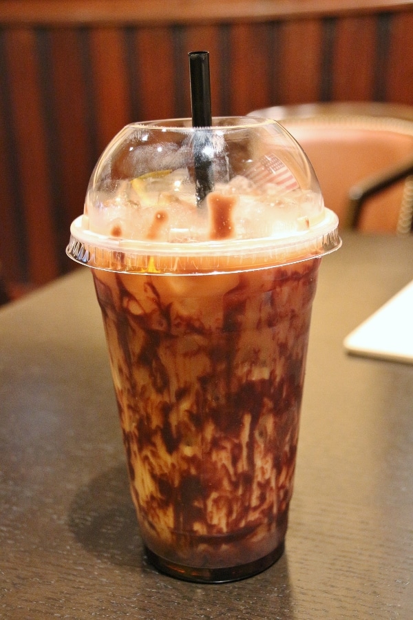 a chocolate iced coffee drink in a disposable plastic cup