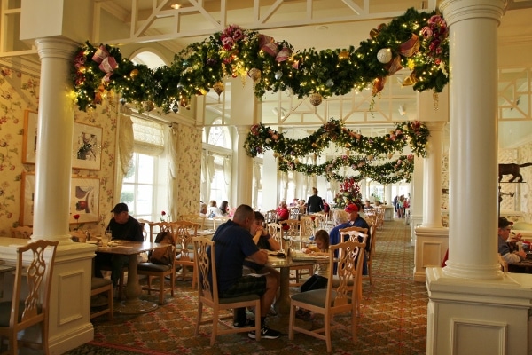 the interior of the Grand Floridian Cafe decorated with Christmas garlands