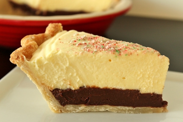 side view of a slice of peppermint mousse black bottom pie on a white plate