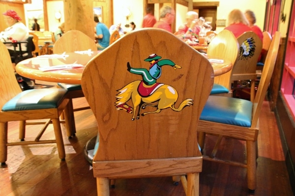 the back of a wooden chair painted with the image of a cowboy