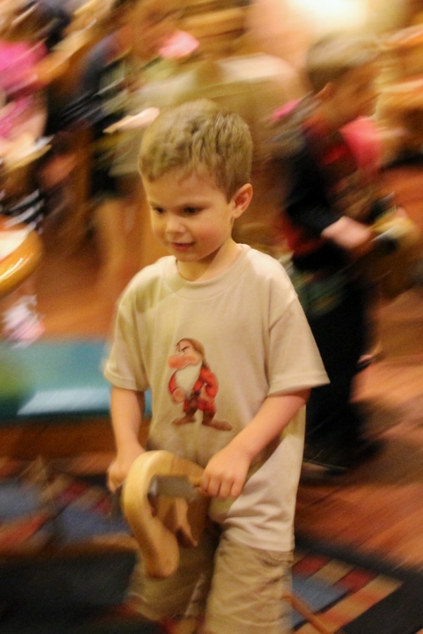 a young boy galloping around on a stick horse