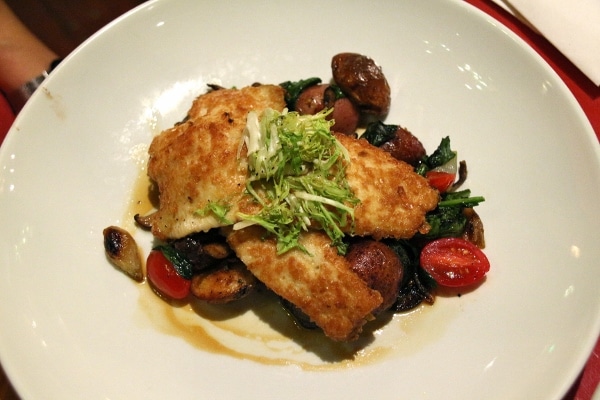 a plate of citrus-glazed rainbow trout over vegetables