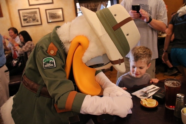 Donald Duck signing an autograph for a young boy