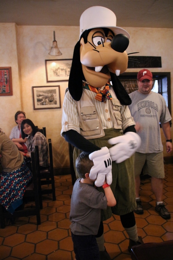 Goofy covering a little boy\'s face with his hand