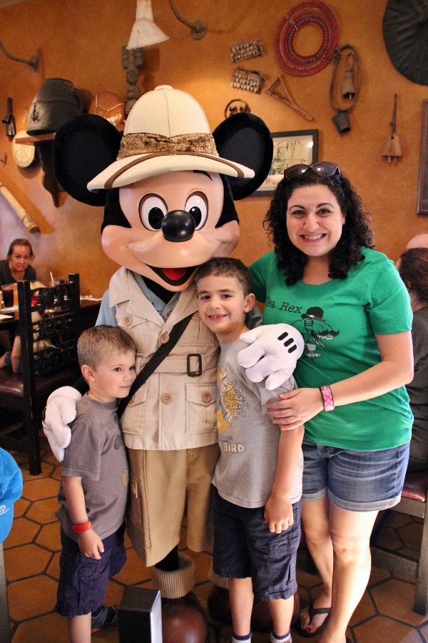 A group of people posing for the camera with Mickey Mouse