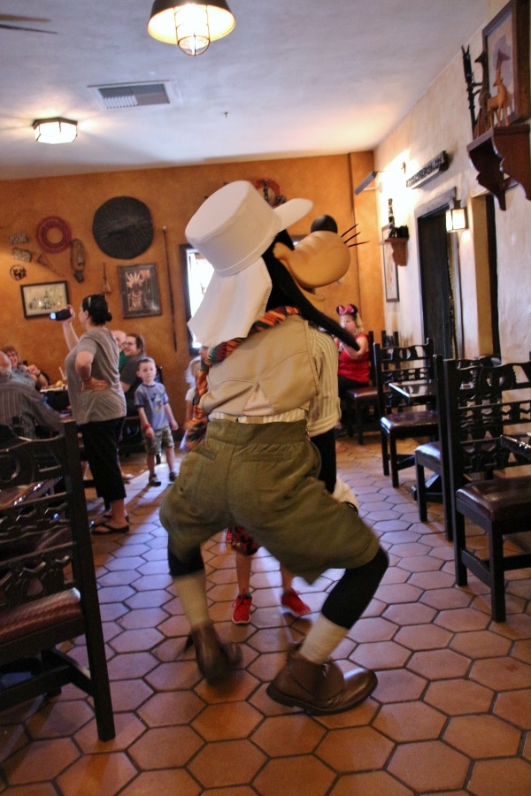 Goofy dancing in the aisle of a restaurant