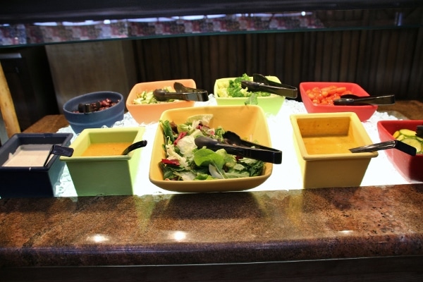 a selection of salads and dressings in a buffet