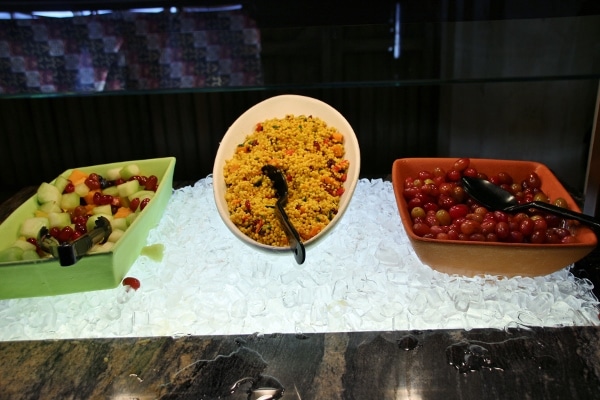 fruit salad, couscous, and tomatoes on a buffet line
