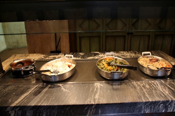 a selection of hot foods on a buffet line