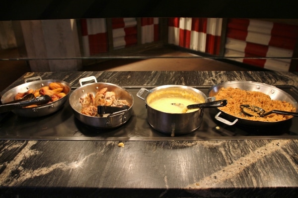 a variety of hot dishes on a buffet line