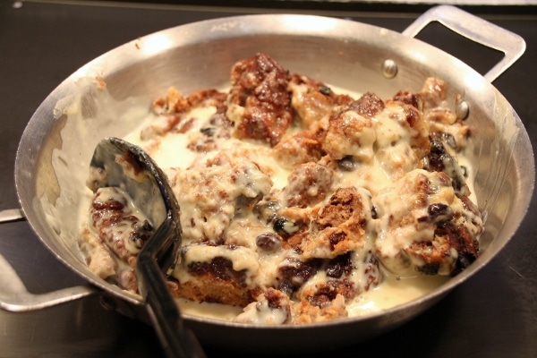 bread pudding with creamy sauce in a pan