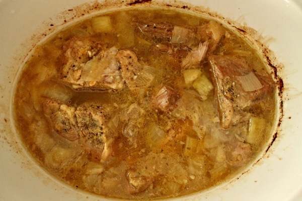 cooked pork in liquid in a slow-cooker