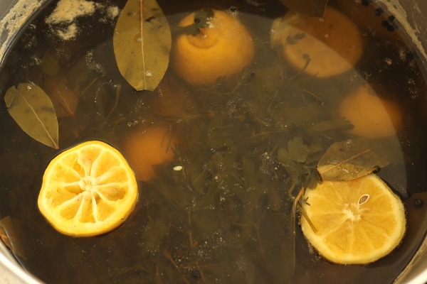 a pot of brine with lemons and herbs