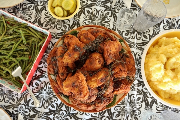 overhead view of a table set with platters of fried chicken and side dishes