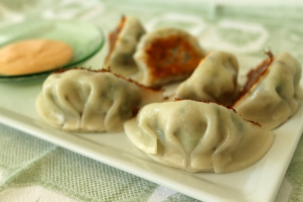 pan-fried pea shoots and leek dumplings on a plate