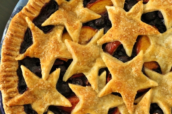 overhead view of a blueberry nectarine pie with star decorations on top