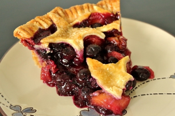 a slice of juicy blueberry nectarine pie on a plate