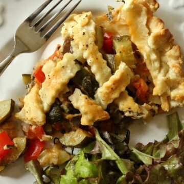 overhead view of a slice of ratatouille pie with salad