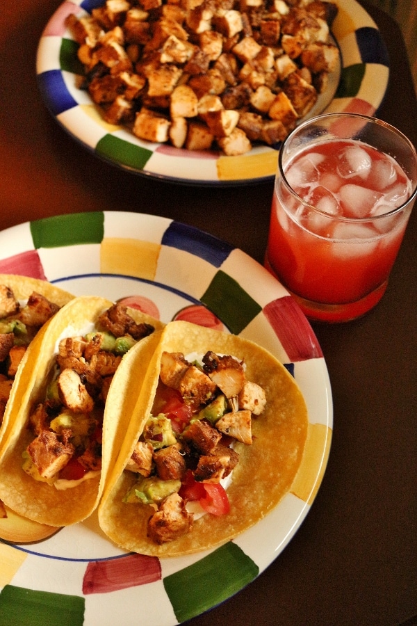 a plate of 3 chicken tacos served with strawberry agua fresca