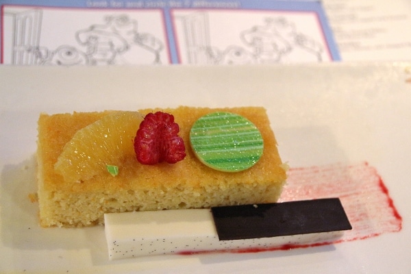 A piece of cake on a plate with a fruit garnish