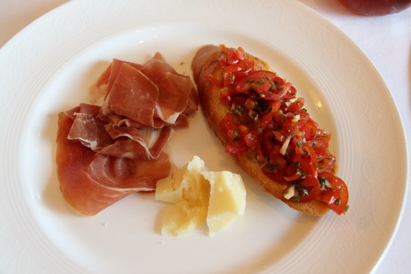 a plate with bruschetta, prosciutto and cheese