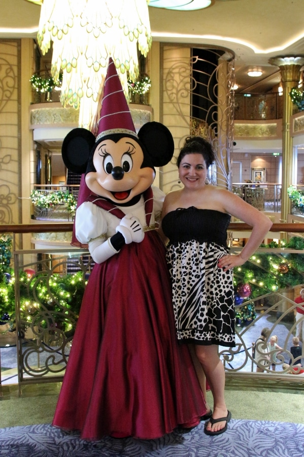 a woman posing with Minnie Mouse dressed as a princess