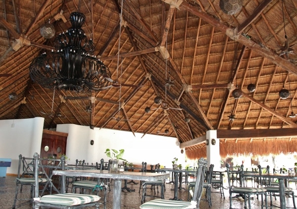 an outdoor restaurant area under a thatched roof