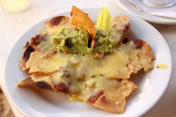 A plate of nachos covered with beans and cheese