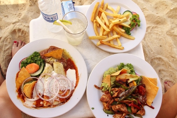 overhead view of plates of enchiladas, chicken fajitas, and fries