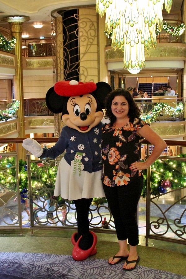 a woman posing with Minnie Mouse dressed in a holiday sweater