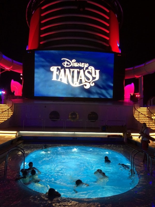 view of the Disney Fantasy pool deck at night