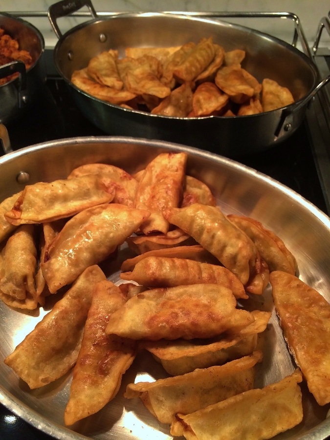 pans of fried dumplings on a buffet