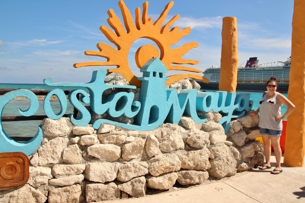 a woman posing with a sign that says Costa Maya