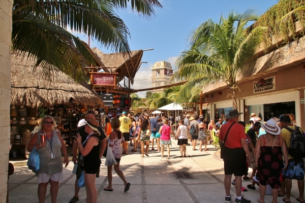 A group of people walking through an outdoor shopping area