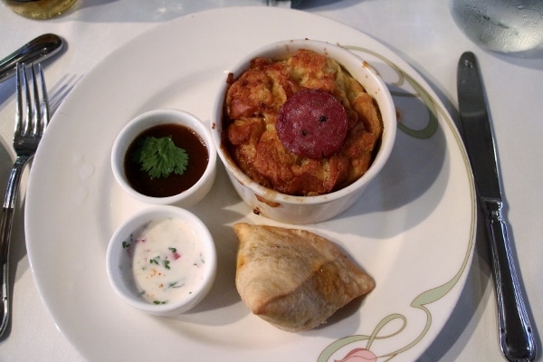 A plate of food with dipping sauces on the side