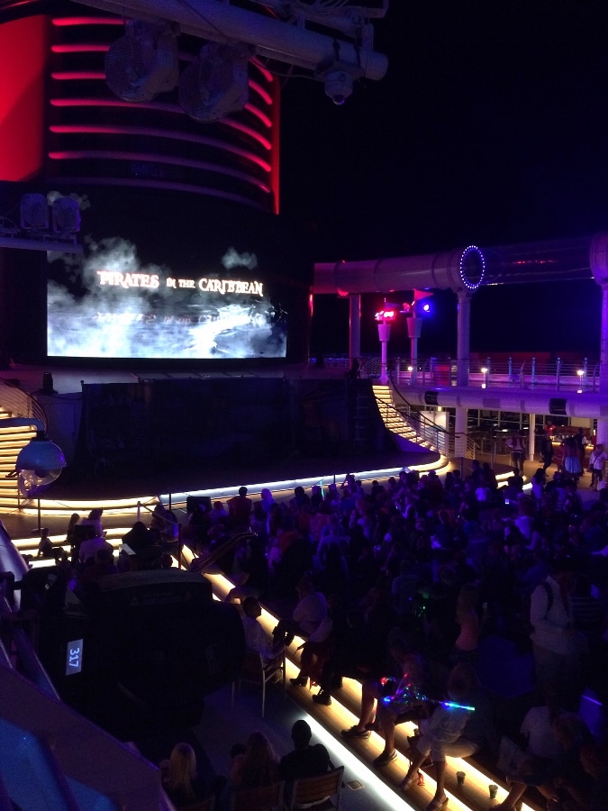 A group of people on the pool deck at night