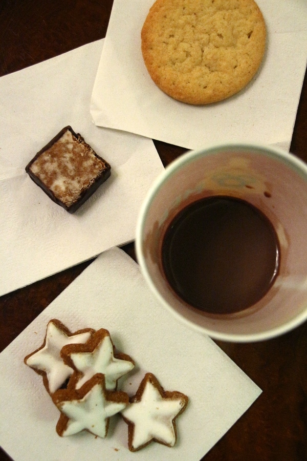 overhead view of a cup of hot chocolate and a variety of small cookies