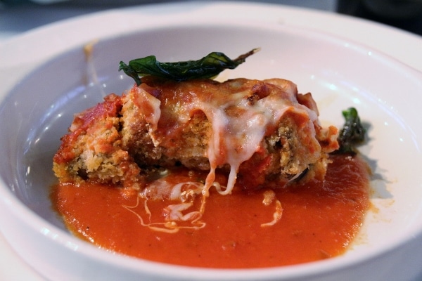 eggplant roll up with cheese on a plate with tomato sauce