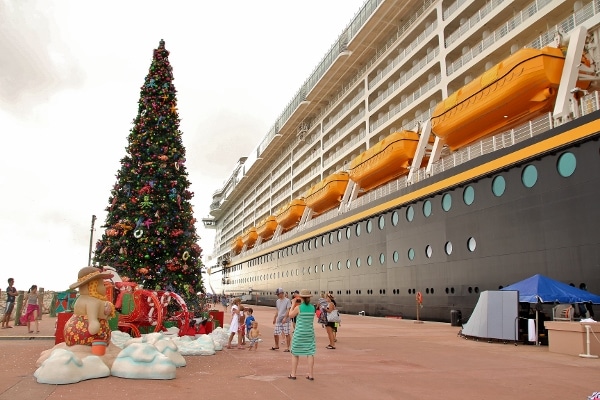 a Christmas tree next to the Disney Fantasy cruise ship