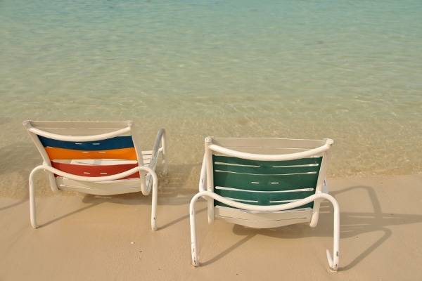 A couple of beach chairs along the shore