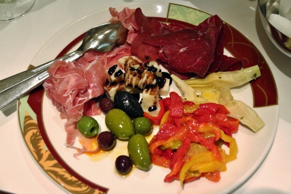 an antipasti plate with cured meats, cheese, and olives