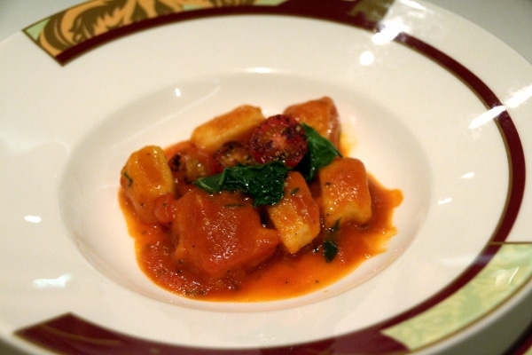 A small plate of gnocchi in tomato sauce