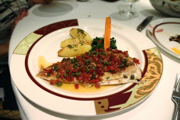 A plate of fish with potatoes and vegetables