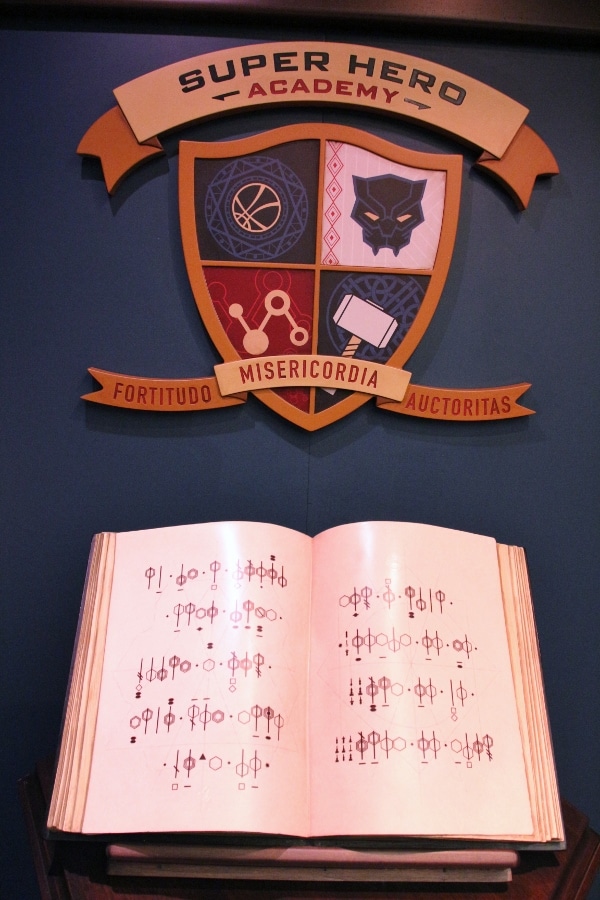 a coat of arms over an open book with codes