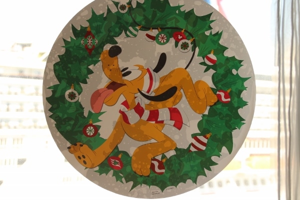 a window decoration with Pluto inside a Christmas wreath