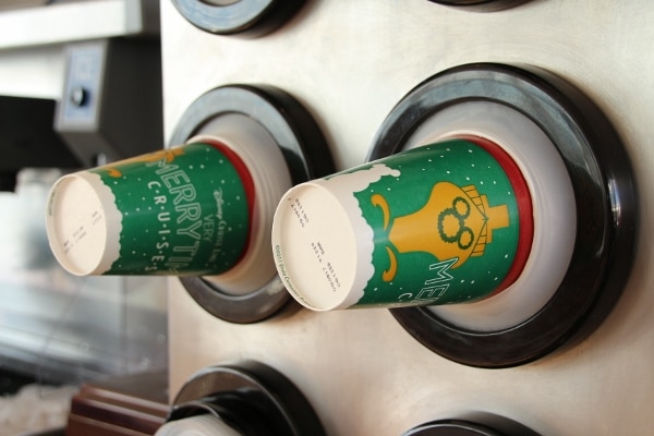 A close up of Very Merrytime Cruise themed paper cups in a dispenser