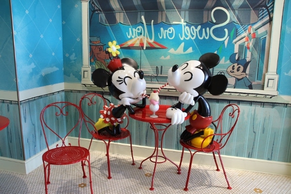 Mickey and Minnie Mouse statues sharing an ice cream