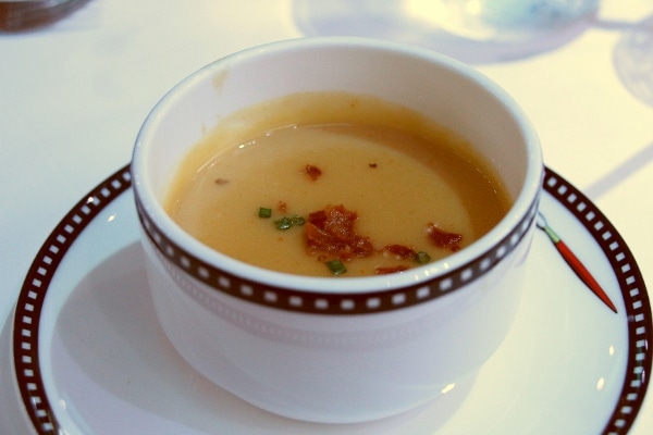 A bowl of soup garnished with bacon